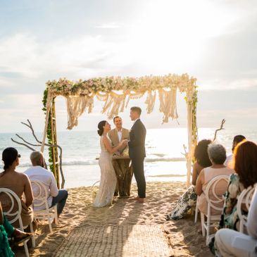 Couple exchanging vows at a beach wedding.
