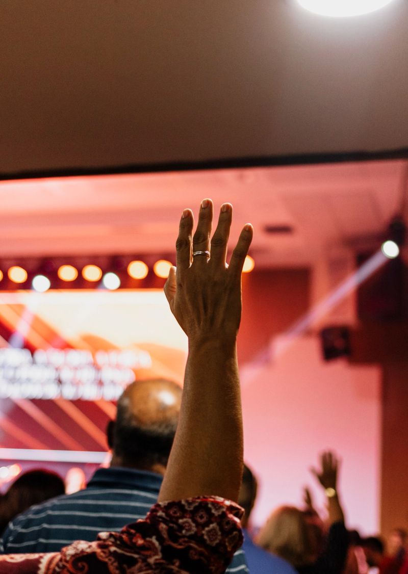 people worshiping and praising God with hands raised in church