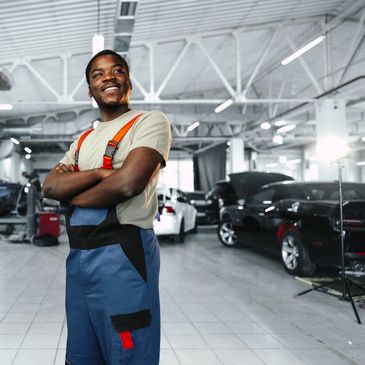 African man mechanic in uniform at the car repair station, portrait, close up