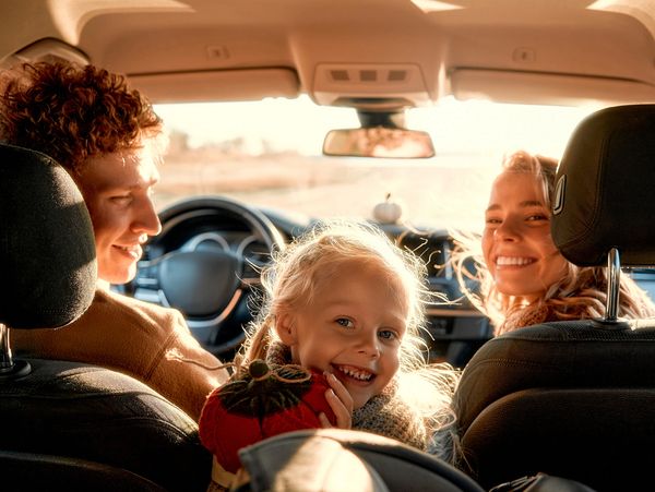 Happy family enjoying a car ride together.