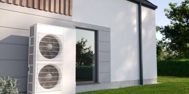 Modern heat pump unit outside a house on a sunny day.