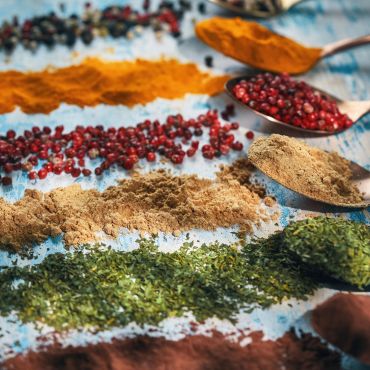 Various colorful spices and herbs arranged on a surface.