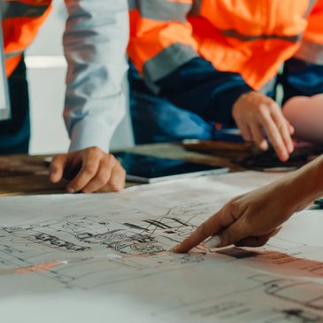 People reviewing architectural plans on a table.