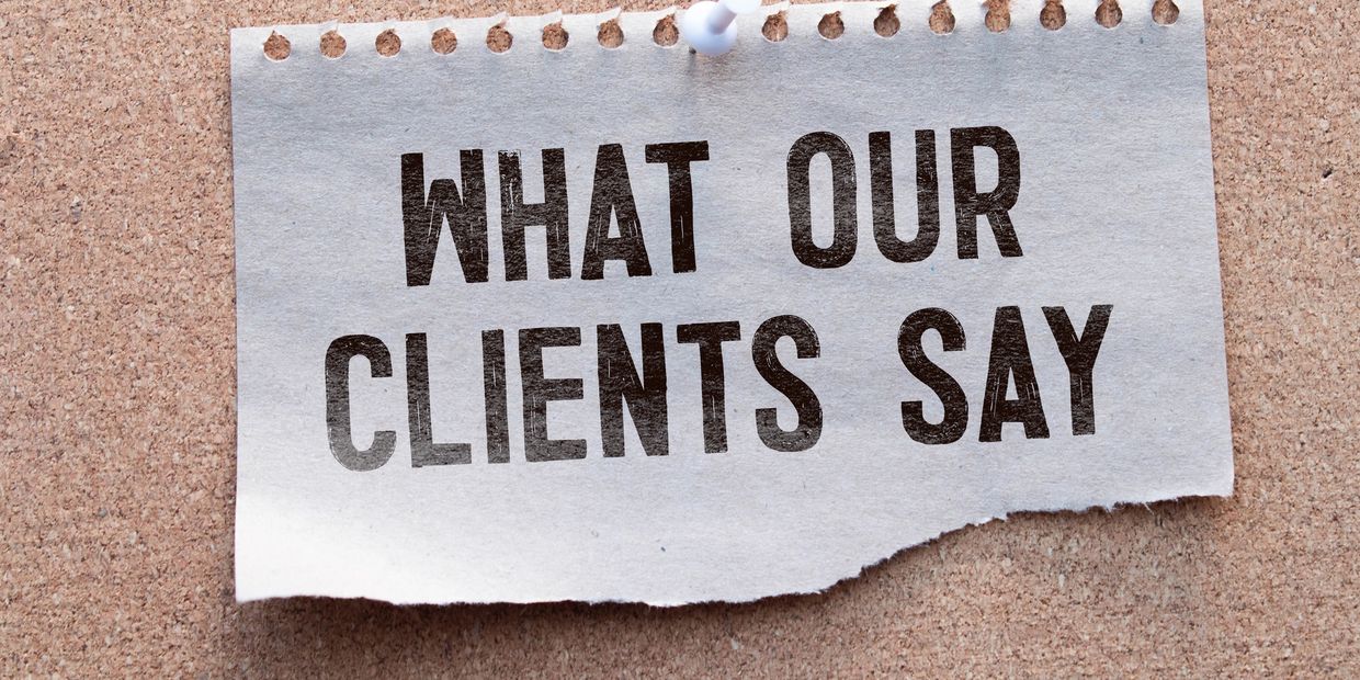 A torn paper pinned on a corkboard reads "WHAT OUR CLIENTS SAY."