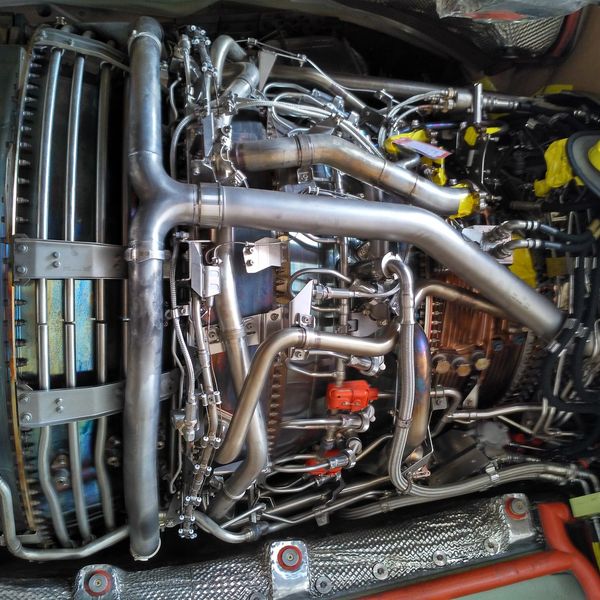 Close-up of a complex aerospace engine with intricate pipes and metallic components.