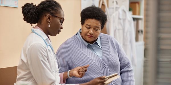 Doctor explaining medical information to a patient using a tablet.