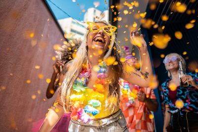 Young woman celebrates with confetti and festive attire.