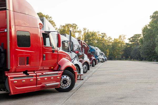 A row of colorful semi-trucks parked in a lot.