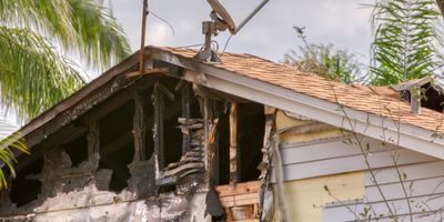 Burned and damaged section of a house roof.