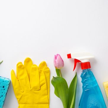 Cleaning supplies and pink tulips arranged on a white background.