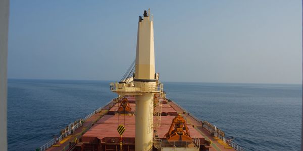 View from the deck of a cargo ship at sea under clear skies.