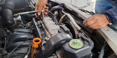 engine being taken apart by a mechanic with a rachet tool 