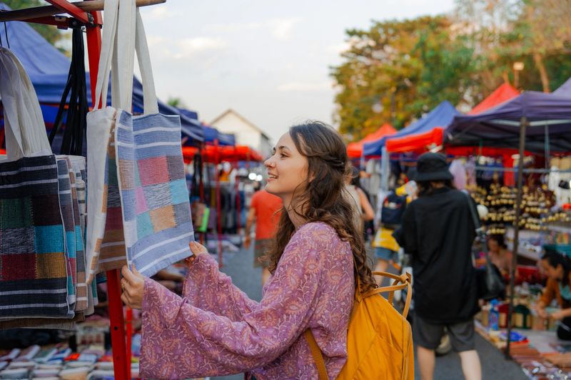 Woman exploring street  market in Luang Prabang during her vacation to Southeast Asia