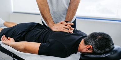 Massage therapist working on back to ease tension and reduce pain, Highanms Park