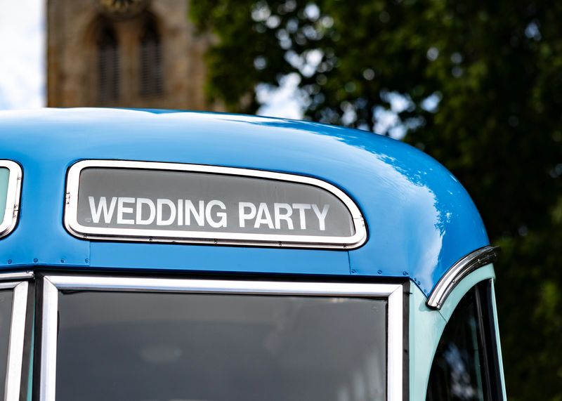 Wedding party bus coach transportation blue old vehicle to transport guests to church capital letters
