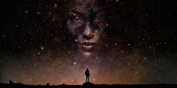 Silhouette of a person under a starry sky with a face formed by stars.