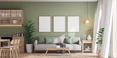 Modern living room with green walls and natural wood furniture.