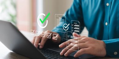 Person working on a laptop with digital checklist.