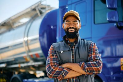 Professional truck driver standing In front semi-truck  andyrailer snd Tonker 