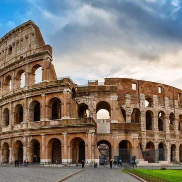 The ancient Colosseum in Rome under a blue sky.