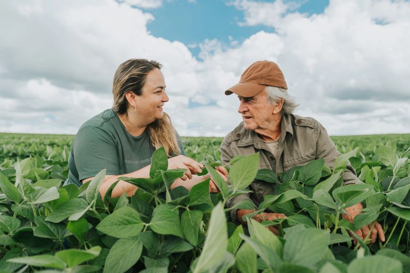 Female agronomist and farmer at soybean crop