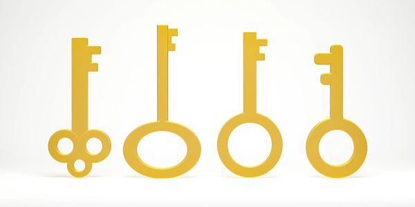 Four gold vintage-style keys with different shaped bows.