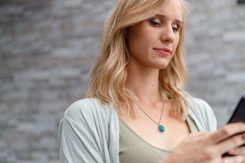 Woman looking at her phone with a gentle smile.