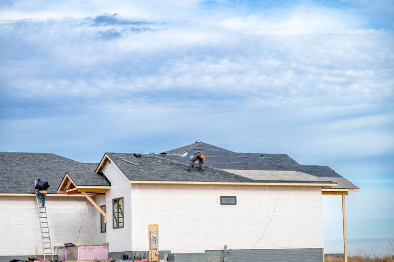 Shingle roof being installed on a two-story walkout new build residential construction house. . High quality photo