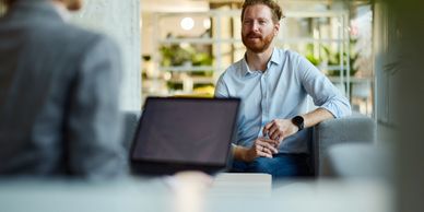 Man having a conversation with a woman in an office setting.