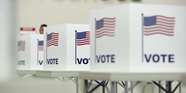Voting booths with American flags and the word VOTE on them.