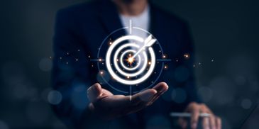 Businessman holding glowing target with arrow hitting the bullseye symbolizing success.
