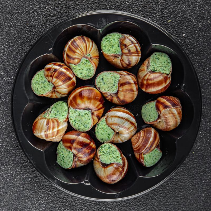 snails with green oil aromatic herbs tasty fresh healthy eating cooking appetizer meal food snack on the table copy space food background rustic top view keto or paleo diet