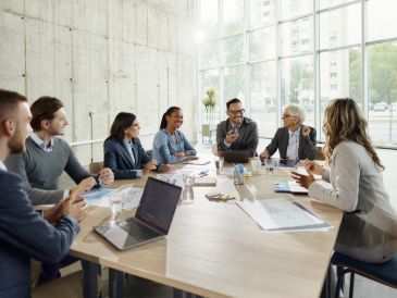 Reunião de trabalho com seis pessoas ao redor de uma mesa.