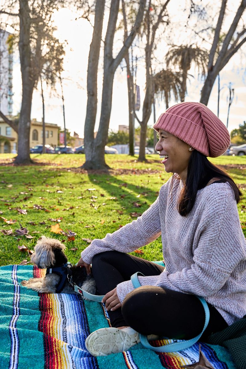Young Woman Interacting Outdoors with their Dog