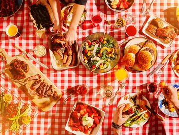 Repas convivial avec hamburgers, salade et fruits.
