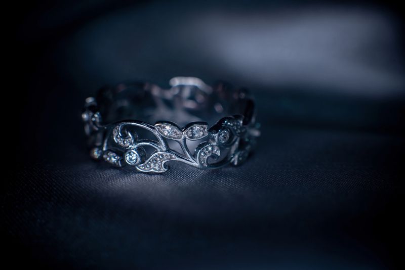 Vintage silver, white gold ring on dark fabric background