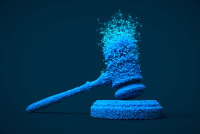 A digital blue gavel dissolving into particles against a dark background.