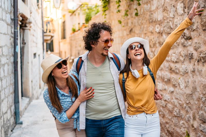 Three young tourists goofing around on the street in Dubrovnik in Croatia.
