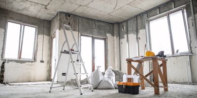 An unfinished room under construction with tools and ladder.