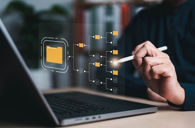 DMS, document management system concept. Businessman using laptop connecting to digital cloud file folder, data transfer backup, digital transformation, file sharing, searching, and managing files.