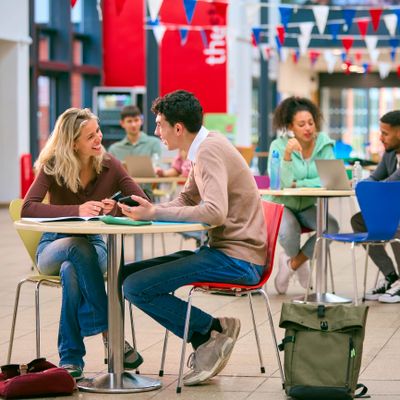 Students studying and chatting in a colorful campus common area.
