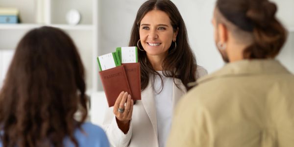 Woman showing passports and boarding passes to a couple.