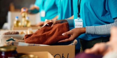 Volunteer packing clothes into a box.