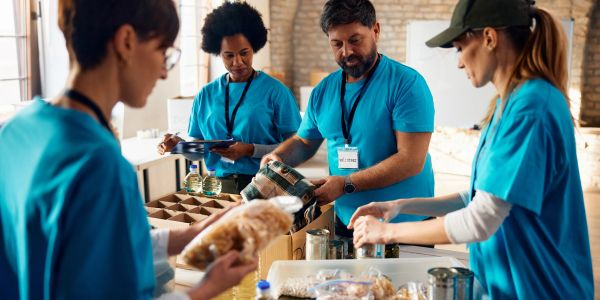 Voluntarios organizando alimentos en cajas.