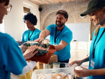 Volunteers happily distributing food at a community service event.
