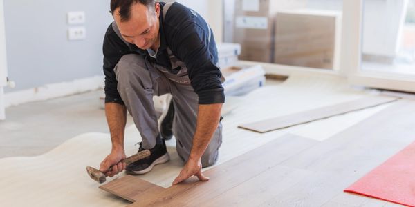 Contractor installing flooring during a home remodel 