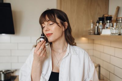 Relaxed woman sitting with a tincture bottle of medical cannabis 