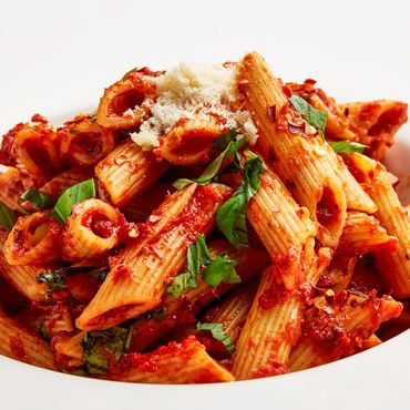 Plato de pasta penne a la Arrabbiata con salsa de tomate picante.