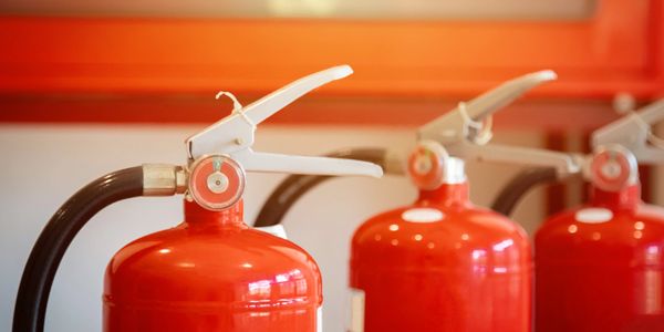 Three red fire extinguishers in a line