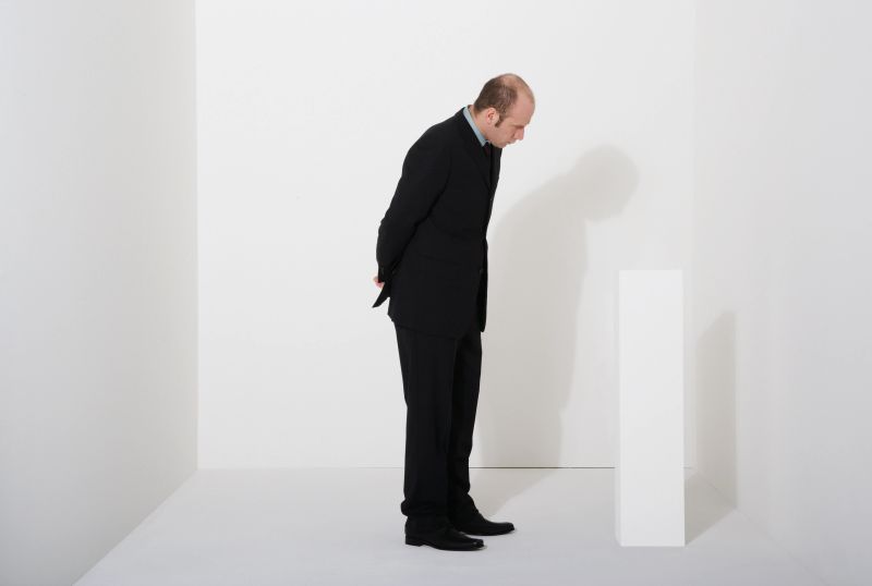 Man looking at white block